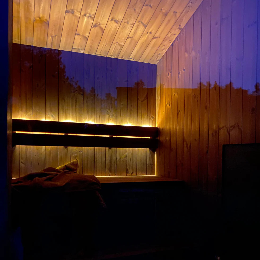 IDYLL Mini innvendig i skumringen, med LED-lys langs benken og mørkeblå kveldshimmel gjennom det store vinduet